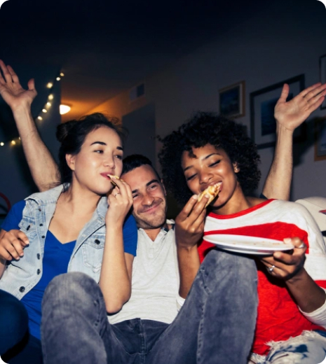 3 friends enjoying a party and eating pizza